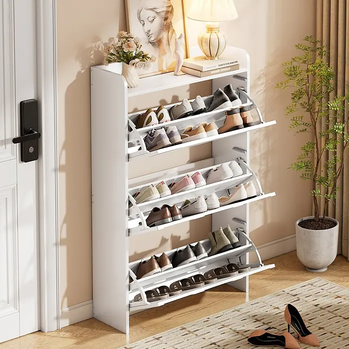 SONNENH Schuhschrank mit Bogenrelief und Klappfächern, Weiß -  - Ein hoher weißer Schuhschrank mit mehreren Klappfächern zur Schuhaufbewahrung, dekoriert mit Lampe und Blumen, im Eingangsbereich mit Schuhen.