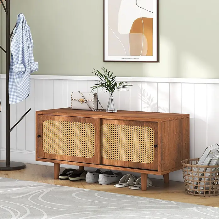 SONNENH Schuhschrank - Walnussoptik - Brauner Holzschrank mit natürlichen Rattan-Schiebetüren, dient als Schuhaufbewahrung im Eingangsbereich mit Schuhen darunter.