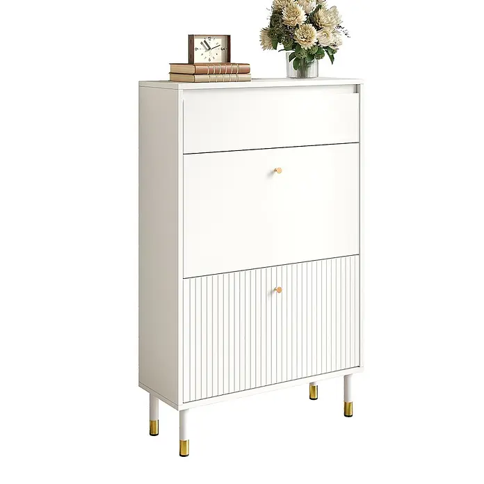SONNENH Schuhschrank mit zwei Klappfächern und Schublade, Weiß -  - Weißer Schrank mit goldenen Knäufen und Beinspitzen, mit einem geriffelten unteren Paneel. Eine Uhr, Bücher und Blumen schmücken die Oberseite.
