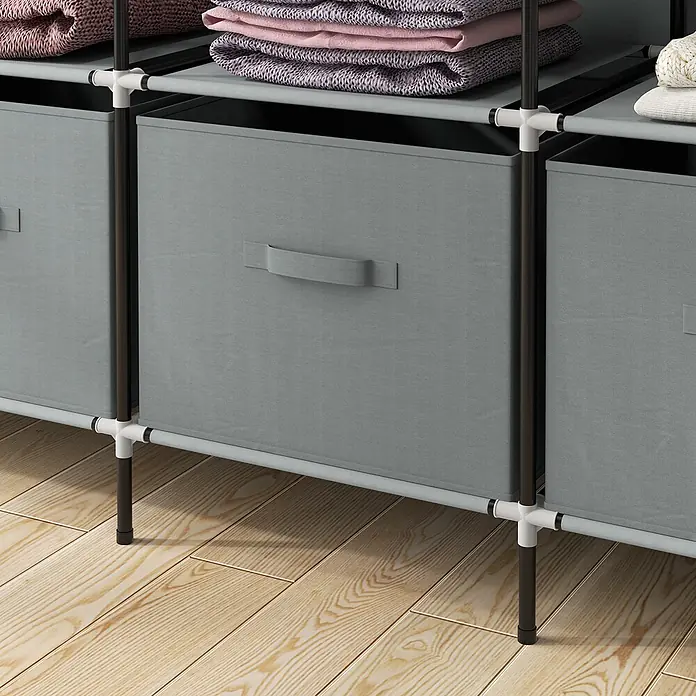 SONNENH Kleiderschrank - Dunkelgrau - Graues Stoff-Ordnungssystem mit schwarzen Stangen und weißen Verbindern, das gefaltete Kleidung aufbewahrt.