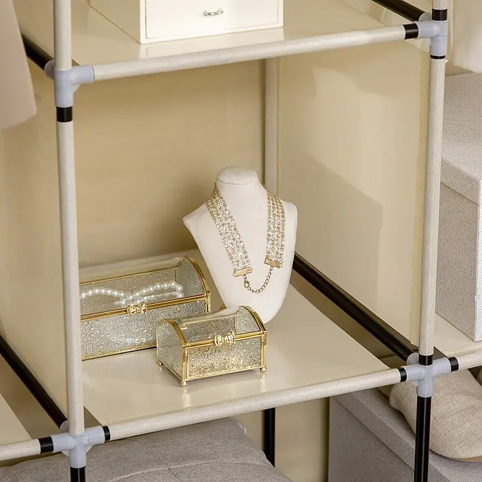 SONNENH Stoff-Kleiderschrank mit 2 Kleiderstangen, Beige -  - Cremefarbenes Stoffregal mit hellgrauen Verbindern, das eine Halskette, Schmuckkästchen und eine weiße Aufbewahrungsbox zeigt.