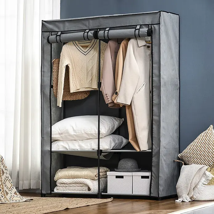 SONNENH Kleiderschrank - Hellgrau - Ein grauer Stoff-Kleiderschrank, mit Kleidung, Kissen und Aufbewahrungsboxen in einem Raum.