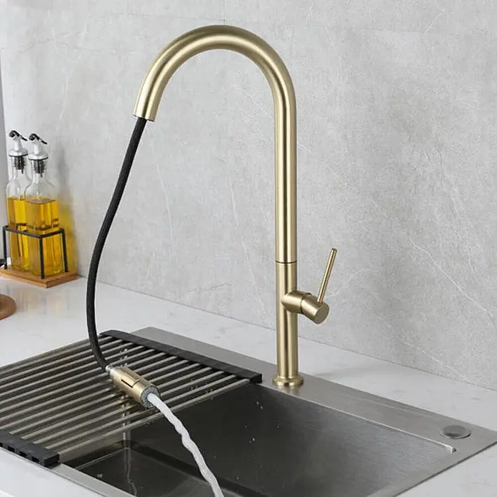 Küchenarmatur Gold gebürstet 1565 -  - Moderne goldene Küchenarmatur mit ausziehbarem Sprühkopf, der Wasser in ein Edelstahlspülbecken mit Roll-Abtropfgestell abgibt.