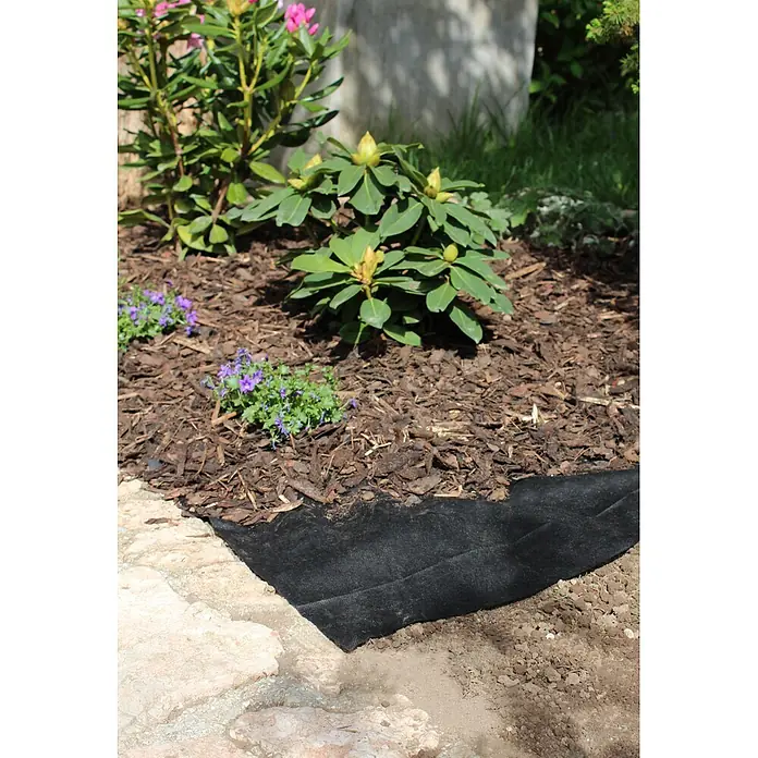 Windhager Unkrautvlies - Vlies, 25 x 2 m - Schwarzes Unkrautvlies auf Gartenboden neben einem Steinweg, teilweise mit Rindenmulch bedeckt.