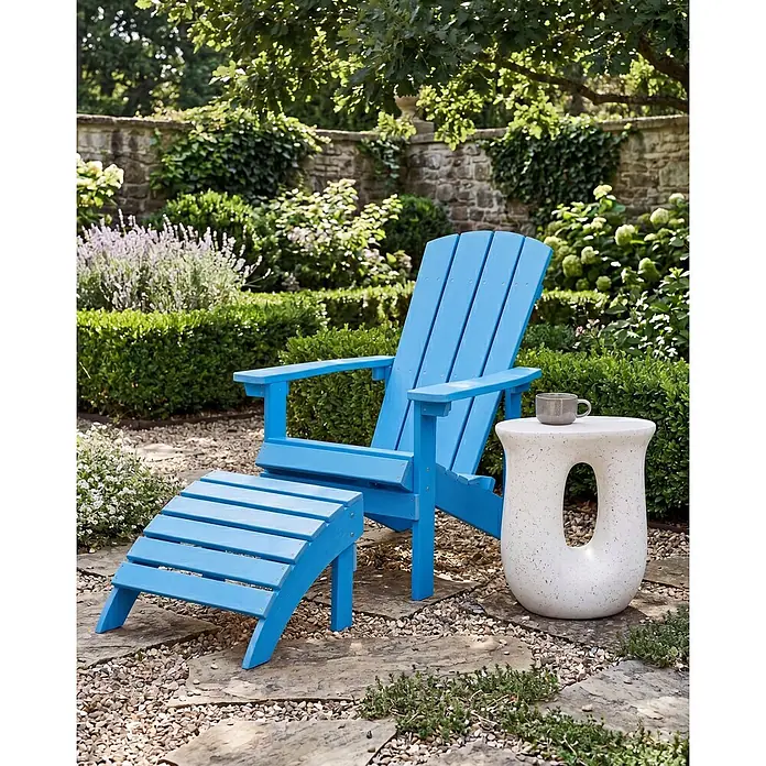 2-tlg Gartenstuhl ADIRONDACK in Blau -  - Blauer Adirondack-Stuhl mit passendem Hocker und weißem Beistelltisch in Gartenumgebung.