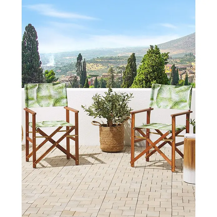 6er-Set Gartenstuhl CINE in Grün/Weiß/Braun -  - Zwei Regiestühle aus Holz mit grünem Palmenblattmuster auf einer Terrasse.