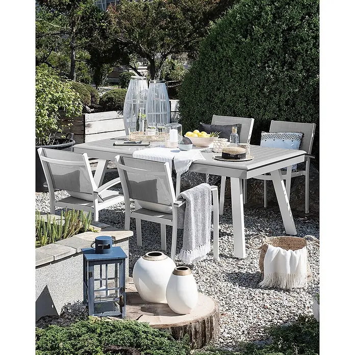 4er-Set Gartenstuhl PERETA in Grau/Weiß -  - Gartensitzgruppe: grauer Tisch mit weißen Beinen und graue Mesh-Stühle mit weißen Rahmen, im Kiesgarten platziert.