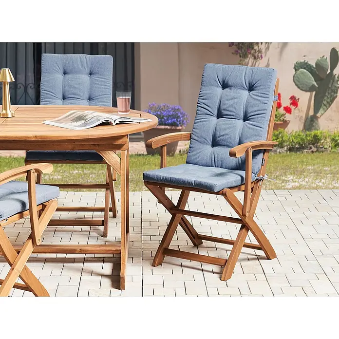 Beliani Gartenstuhl-Set MAUI PREMIUM - 2 Stk., Akazienholz, Klappbar, Braun, B x T x H: 46 x 48 x 92 cm - Esstischgarnitur aus Holz für den Außenbereich mit blauen Kissen auf einer Terrasse. Sie besteht aus einem runden Tisch und klappbaren Stühlen.