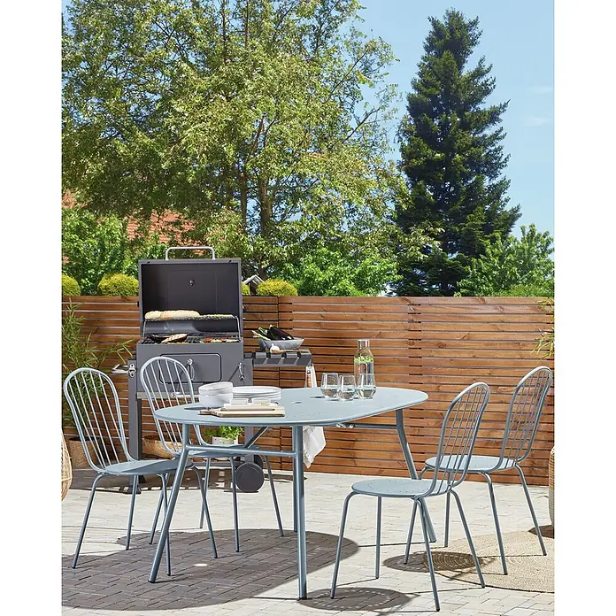 Beliani Gartenstuhl-Set CALVI - 8 Stk., Stahl, Blau, B x T x H: 40 x 47 x 89 cm - Eine graue Outdoor-Sitzgruppe aus Metall mit ovalem Tisch und vier Stühlen, daneben ein passender grauer Grill auf einer Terrasse.