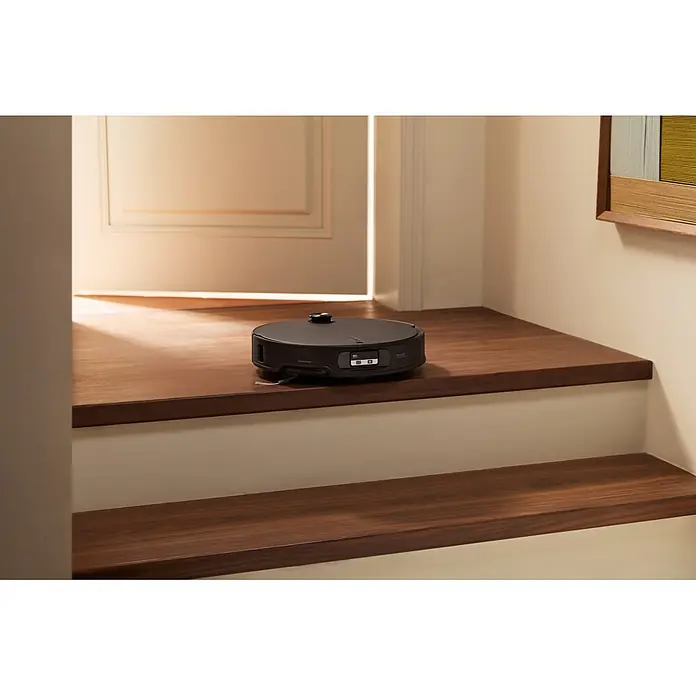 Roborock Saugwischroboter Qrevo Edge 2X - Saugkraft: 25.000 Pa, Akkulaufzeit: 188 min, Fassungsvermögen Roboter: 240 ml, Schwarz - Dunkelgrauer Saugroboter auf einer Holztreppenstufe platziert.