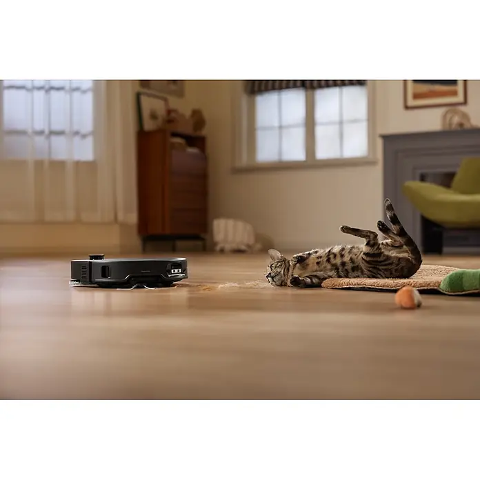 Roborock Saugwischroboter Qrevo Edge 2X - Saugkraft: 25.000 Pa, Akkulaufzeit: 188 min, Fassungsvermögen Roboter: 240 ml, Schwarz - Schwarzer Saugroboter auf Holzboden nahe einer Katze, bereit Tierhaare zu reinigen.