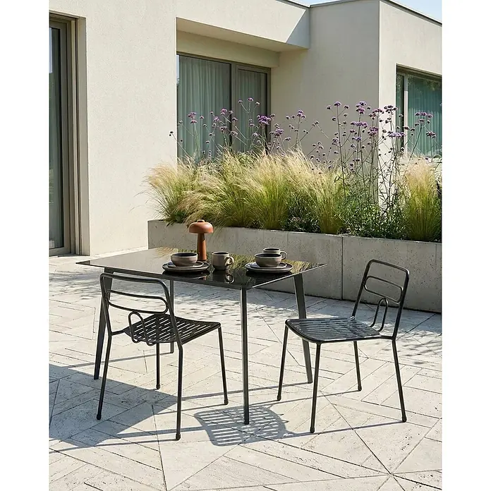 2er-Set Gartenstuhl AGEROLA in Schwarz -  - Schwarzer rechteckiger Metalltisch mit zwei passenden Stühlen auf einer Terrasse, mit Geschirr für Mahlzeiten im Freien gedeckt.