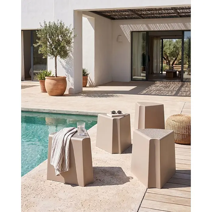 4er-Set Gartenstuhl EVROS in Beige/Braun -  - Vier beige, polygonale Outdoor-Hocker/Beistelltische mit perforierten Oberflächen, am Pool auf einer Terrasse.