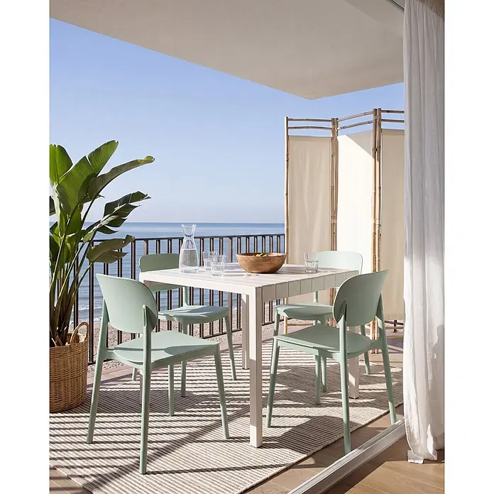 4er-Set Gartenstuhl TUPIZA in Grün -  - Weißer Gartentisch mit vier mintgrünen Stühlen auf einem Balkon mit Meerblick.