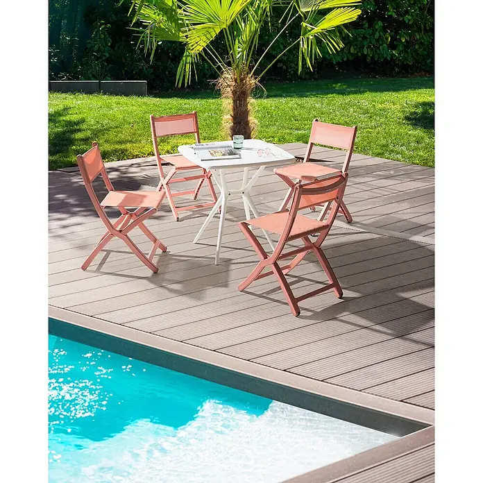 4er-Set Gartenstuhl TALCA in Rot -  - Korallenfarbene Klappstühle und ein weißer Tisch auf einer Holzterrasse am Pool.