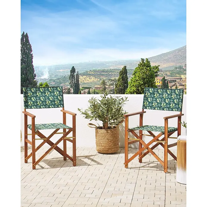 6er-Set Gartenstuhl CINE in Grün/Weiß/Braun -  - Zwei Regiestühle aus Holz mit Stoff in Olivenmuster auf einem Balkon mit Blick auf eine Landschaft.