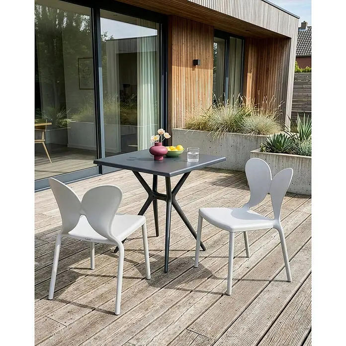 2er-Set Gartenstuhl LARISSA in Grau -  - Dunkelgrauer quadratischer Outdoor-Tisch mit einzigartigem Fuß und zwei hellgrauen Stühlen mit markanten Rückenlehnen auf einer Holzterrasse.