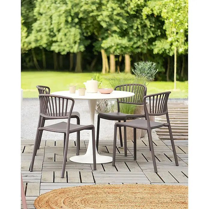 4er-Set Esszimmerstuhl GELA in Beige -  - Ein weißer Outdoor-Tisch mit vier dunkelgrauen Stühlen auf einer Terrasse.