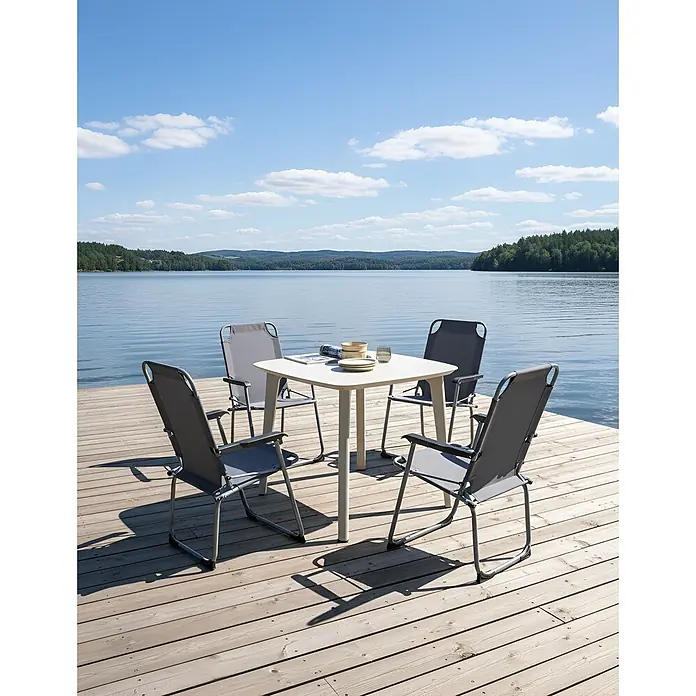 4er-Set Gartenstuhl GALATSI in Grau/Schwarz -  - Weißer quadratischer Gartentisch mit vier grauen Klappstühlen auf einem Holzsteg am See, bereit zum Essen.
