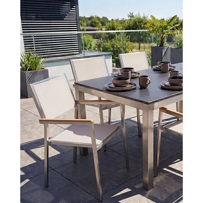 6er-Set Gartenstuhl GROSSETO in Beige/Silber/Braun -  - Eine Outdoor-Essgruppe mit dunkelgrauem Tisch und hellbeigen Stühlen, gebürsteten Metallrahmen und Holzarmlehnen auf einer Terrasse.