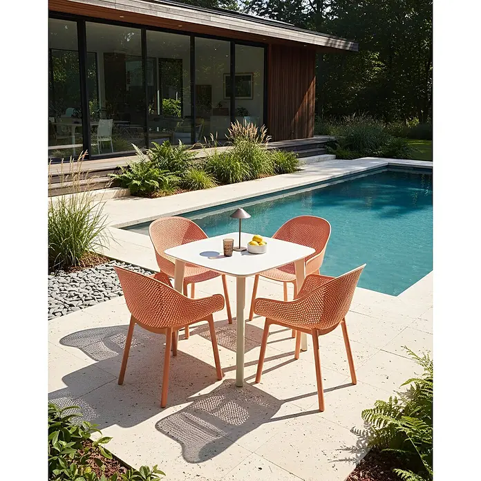 4er-Set Esszimmerstuhl TIGGIANO in Orange -  - Gartensitzgruppe mit vier pfirsichfarbenen Stühlen und einem weißen Tisch neben einem Swimmingpool.