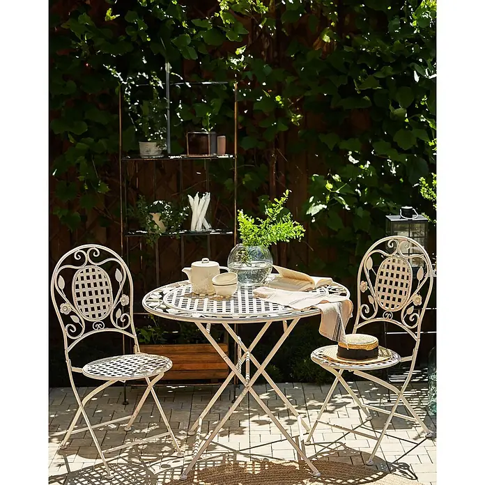 4er-Set Gartenstuhl BIVIO in Weiß -  - Antikweißer Metall-Bistro-Set mit rundem Tisch und zwei Stühlen auf einer Gartenterrasse.