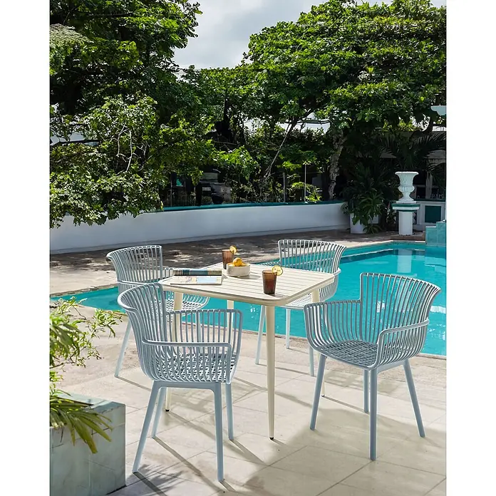 4er-Set Esszimmerstuhl PESARO in Blau -  - Hellblaue Outdoor-Stühle mit Lattenrost und beiger Tisch am Pool, für Getränke gedeckt.