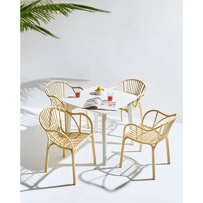 4er-Set Esszimmerstuhl ANDORA in Beige -  - Outdoor-Essgruppe mit weißem Tisch und vier hellen Rattanstühlen, dekoriert mit Getränken und einer Zeitschrift.