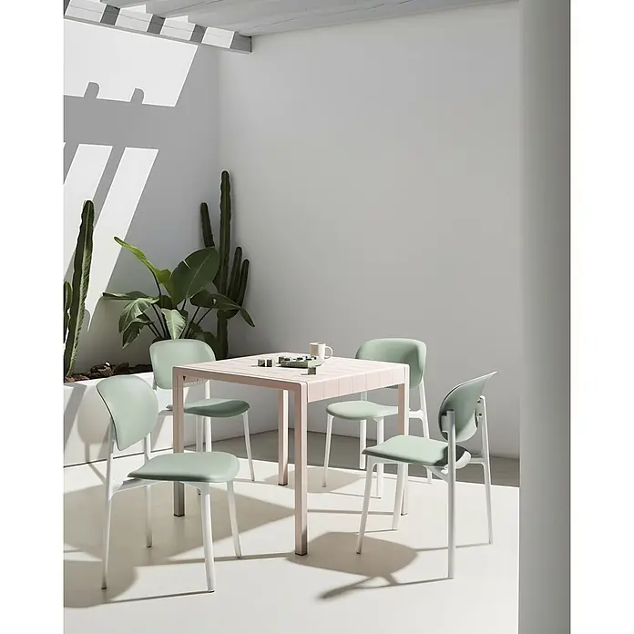 4er-Set Esszimmerstuhl MUSANO in Grün/Weiß -  - Hellrosa quadratischer Tisch mit hellgrünen Stühlen, im Freien zwischen Pflanzen für Essen oder Freizeit arrangiert.