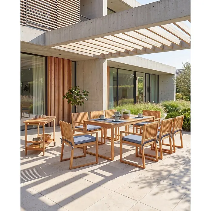 Beliani Gartenstuhl-Set SASSARI II - 8 Stk., zertifiziertes Akazienholz, Braun, B x T x H: 54 x 59 x 80 cm - Outdoor-Esstischgruppe aus Holz mit blauen Kissen und passendem Servierwagen auf einer Terrasse.