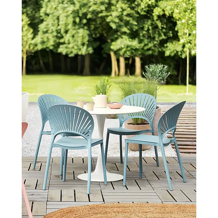 4er-Set Esszimmerstuhl OSTIA in Blau -  - Vier hellblaue Stühle mit Lamellenrücken und ein weißer runder Tisch auf einer Terrasse zum Essen.