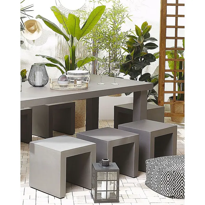 2er-Set Gartenstuhl TARANTO in Grau -  - Moderne Outdoor-Essgruppe mit grauem Tisch und quadratischen Hockern auf gefliestem Patio, umgeben von Pflanzen.