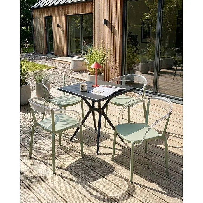 4er-Set Gartenstuhl MALEVIZI in Grün/Transparent -  - Essgruppe für draußen: schwarzer Tisch mit sternförmigem Gestell und hellgrüne Stühle mit transparenten Lehnen auf Holzterrasse.