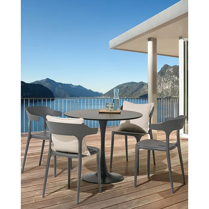 4er-Set Gartenstuhl GUBBIO in Grau -  - Gartensitzgruppe: vier graue Stühle mit hellen Kissen und ein dunkelgrauer Tisch auf einem Holz-Balkon mit Seeblick.