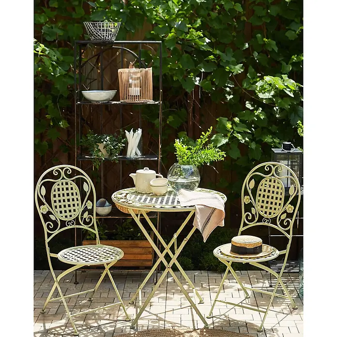 2er-Set Gartenstuhl BIVIO in Grün -  - Hellgrünes Metall-Bistro-Set mit dekorativem Gitterdesign, bestehend aus einem runden Klapptisch und zwei passenden Stühlen auf einer Terrasse.