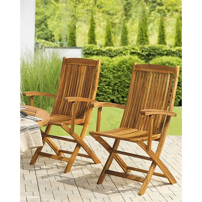 2er-Set Gartenstuhl MAUI in Braun -  - Zwei klappbare Gartenstühle aus Naturholz auf einer Terrasse, bereit für Mahlzeiten im Freien.