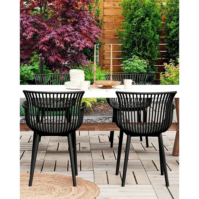 4er-Set Esszimmerstuhl PESARO in Schwarz -  - Schwarze Outdoor-Stühle mit Lattenrost und gebogener Rückenlehne an einem weißen Terrassentisch.