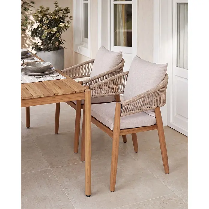 Beliani Gartenstuhl-Set MARZAMEMI - 2 Stk., Akazienholz, Braun, B x T x H: 59 x 53 x 87 cm - Esstisch und zwei Stühle aus Holz mit geflochtenen Seillehnen und hellen Polstern auf einer Terrasse.