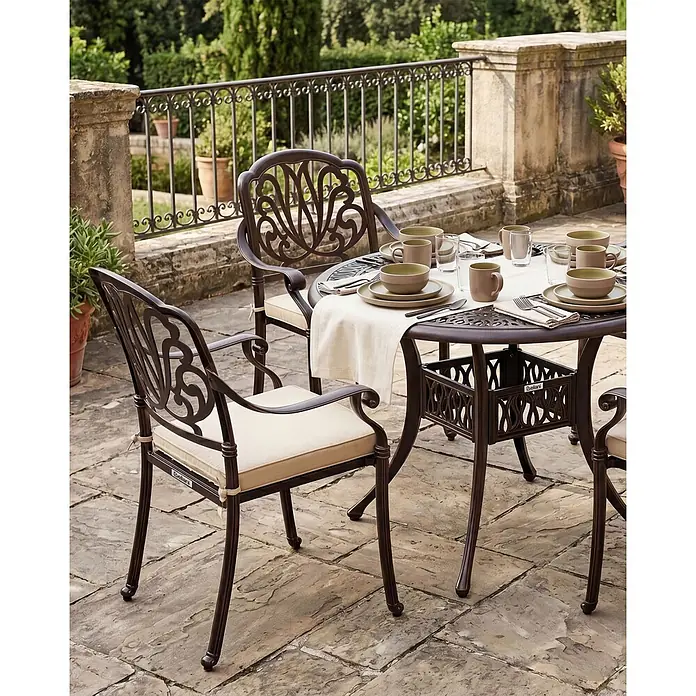 8er-Set Gartenstuhl ANCONA in Braun/Beige -  - Dunkelbraunes Metall-Gartenset mit eleganten Stühlen und rundem Tisch, hellbeigen Kissen, auf einer Steinterrasse platziert.