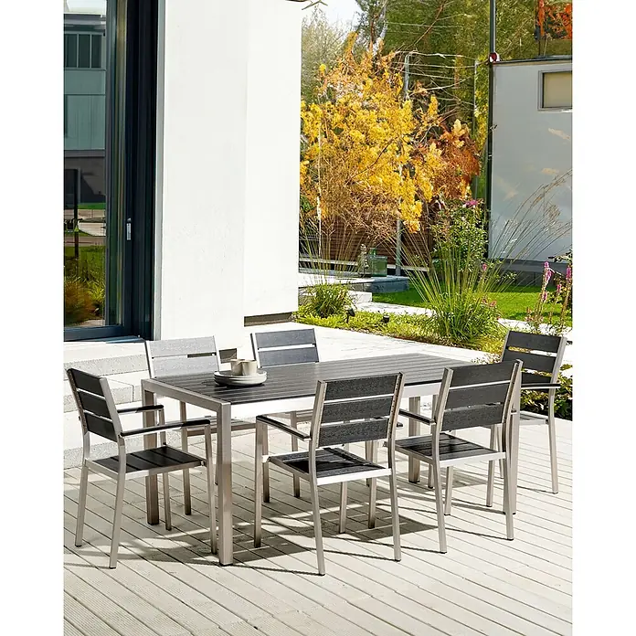 Beliani Gartenstuhl-Set VERNIO - 6 Stk., Kunstholz, Stapelbar, Schwarz, B x T x H: 54 x 57 x 88 cm - Outdoor-Essgruppe mit dunklem Lamellentisch und sechs passenden Stühlen auf hellem Holzdeck.