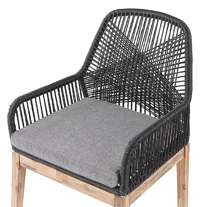 Beliani Gartenstuhl-Set OLBIA - 2 Stk., Akazienholz, Schwarz, B x T x H: 64 x 71 x 89 cm - Ein moderner Stuhl mit schwarzem Flechtwerk, grauem Kissen und hellen Holzbeinen.