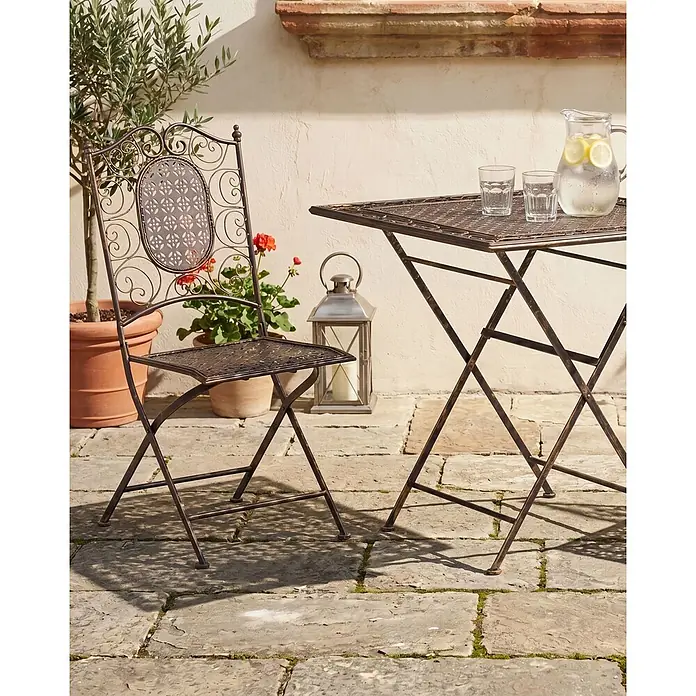 2er-Set Gartenstuhl BORMIO in Schwarz/Gold -  - Bronzefarbenes Metall-Klappstuhl- und Tisch-Set, auf einer Terrasse mit einem Getränkekrug.
