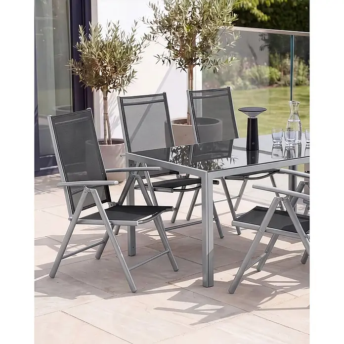 6er-Set Gartenstuhl CATANIA in Schwarz/Silber -  - Graue Metall- und Glas-Essgruppe für den Außenbereich mit schwarzen Netzstühlen auf einer Terrasse.