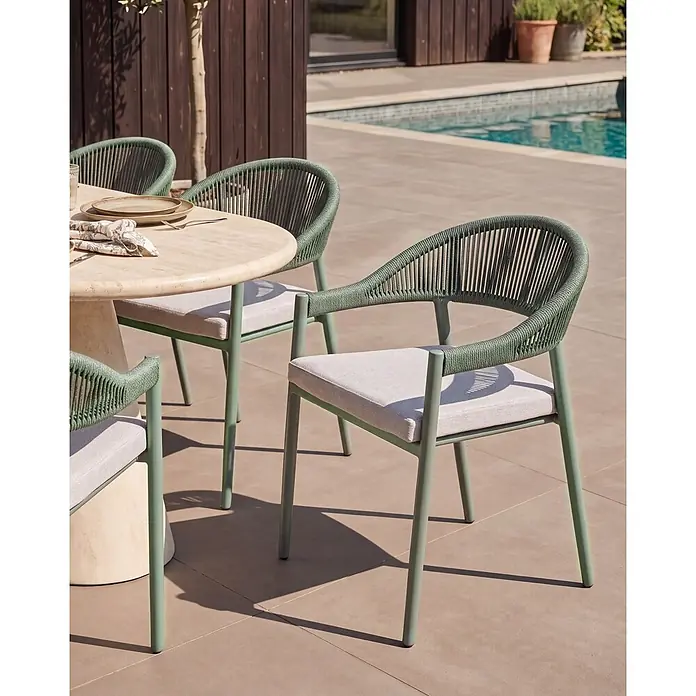 Beliani Gartenstuhl-Set ORMEA - 4 Stk., Aluminium, Grün, B x T x H: 56 x 54 x 80 cm - Grüne Outdoor-Essstühle mit geflochtenen Rückenlehnen und hellen Kissen um einen Steintisch am Pool.