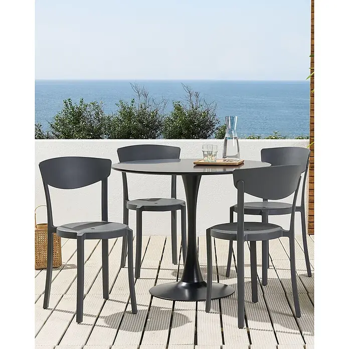 4er-Set Esszimmerstuhl VIESTE in Grau -  - Dunkelgraue Outdoor-Essgruppe mit rundem Tisch und vier Stühlen auf einer Terrasse mit Meerblick.
