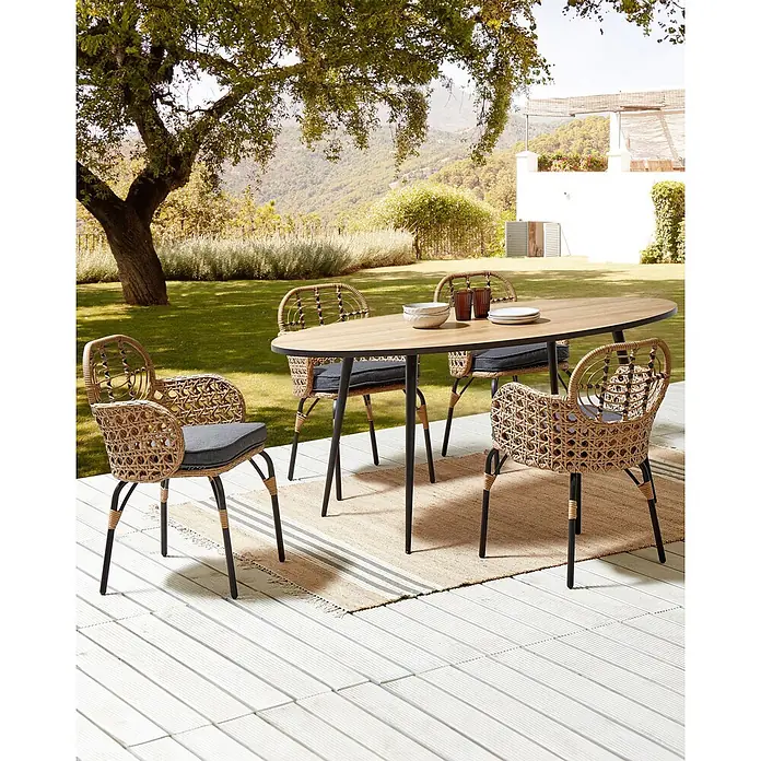 8er-Set Gartenstuhl PRATELLO in Naturfarben/Beige/Grau -  - Ovaler Outdoor-Esstisch mit Holzplatte und schwarzen Beinen, dazu vier geflochtene Rattanstühle mit dunkelgrauen Kissen auf einer Terrasse.