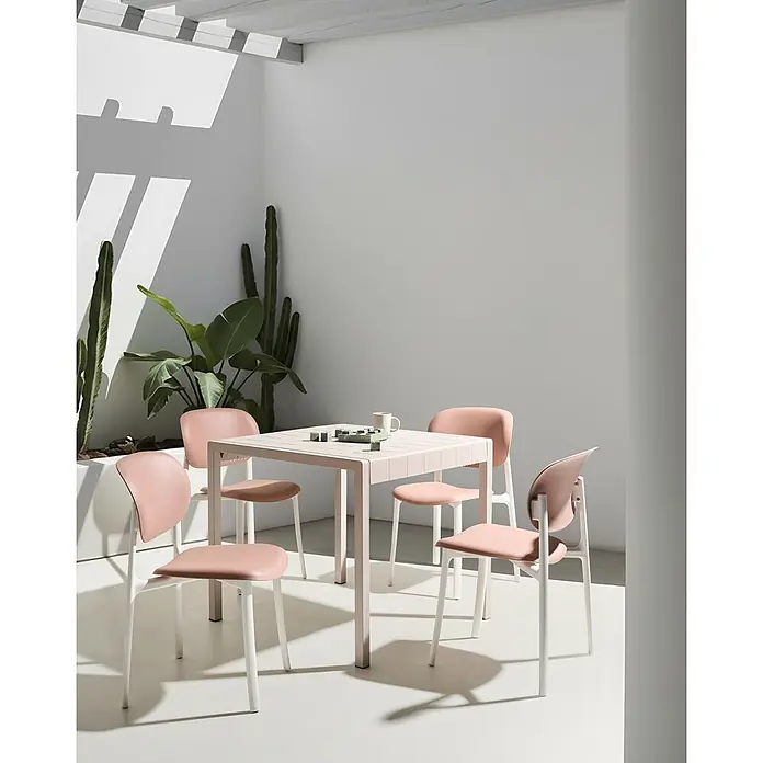 4er-Set Esszimmerstuhl MUSANO in Rosa/Weiß -  - Gartenessgruppe: Ein hellrosa Tisch und vier passende Stühle mit weißen Gestellen, auf einer sonnigen Terrasse.