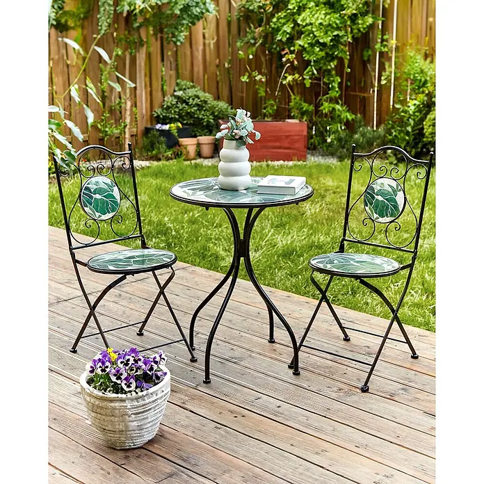 2er-Set Gartenstuhl COZZANA in Schwarz/Grün -  - Schwarzes Metall-Bistro-Set mit grünen Blättern auf Tisch und zwei Stühlen auf Holzterrasse im Garten.