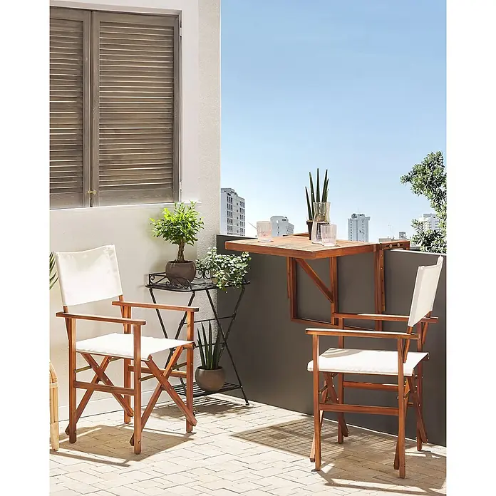2er-Set Gartenstuhl CINE in Weiß/Braun -  - Zwei Holz-Regiestühle mit weißem Stoff und ein wandmontierter Holzbalkontisch auf einer sonnigen Terrasse.