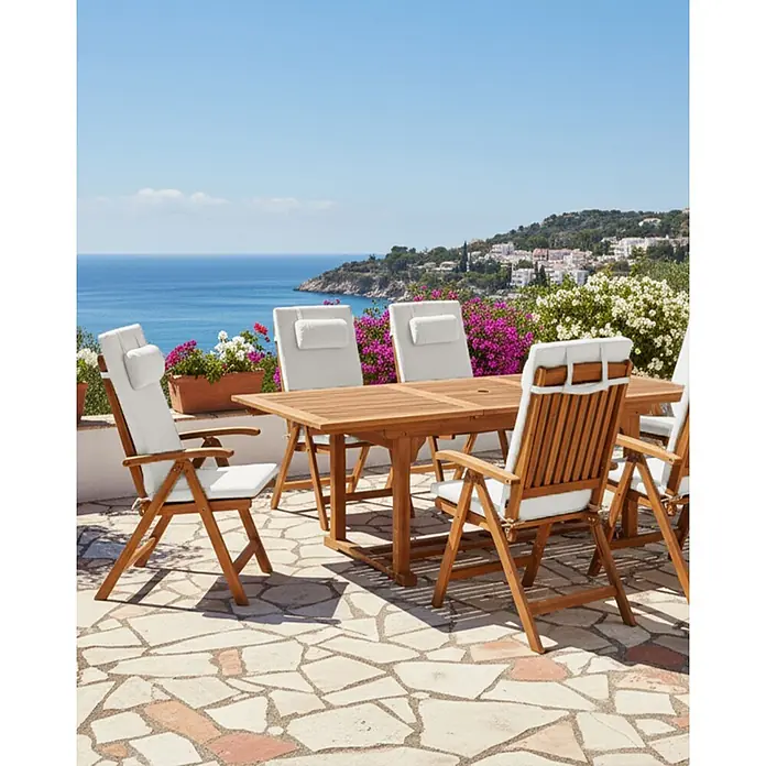Gartenstuhl 6er Set mit Auflagen Hellbraun u. Cremeweiß Akazienholz Verstellbar Klappbar UV-Beständig Rustikal Landhaus Stil Balkon Terrasse Möbel -  - Outdoor-Essgruppe aus Holz mit weißen Kissen auf einer Terrasse mit Meer- und Küstenblick.